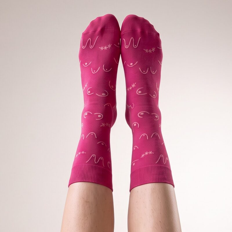Chaussettes Octobre Rose portées, jambes levées contre un mur